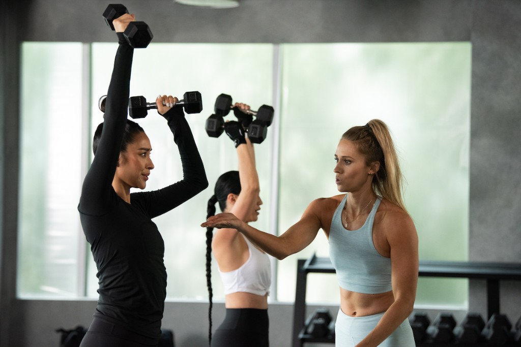 Kelsey coaching a client through an overhead dumbbell press